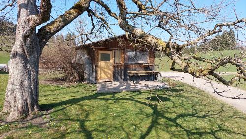 Gartenhaus, davor ist eine Sitzgelegenheit