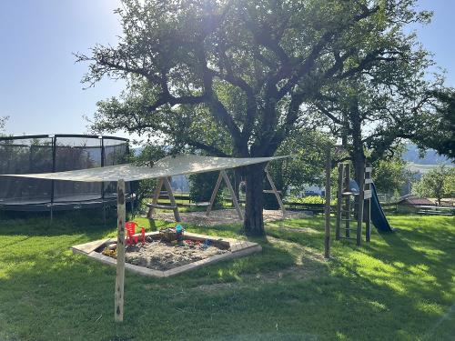 Spielplatz mit Trampolin, Schaukel, Rutsche, Sandkasten und Holzpferd