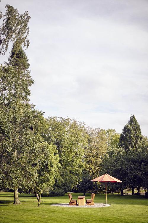 Sonniger Garten mit Sitzgruppen und Liegestühlen