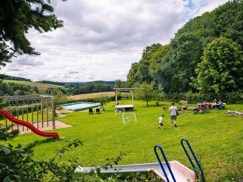 vom Balkon Blick zum Garten mit Spielplatz und Pool