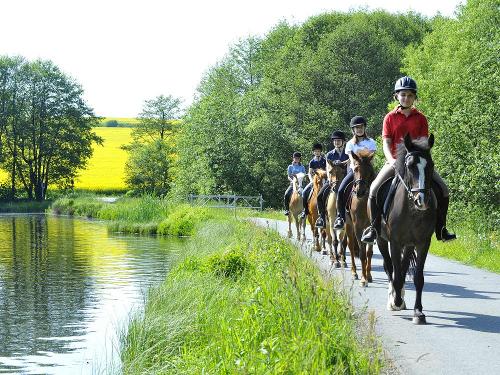 Reitergruppe am See