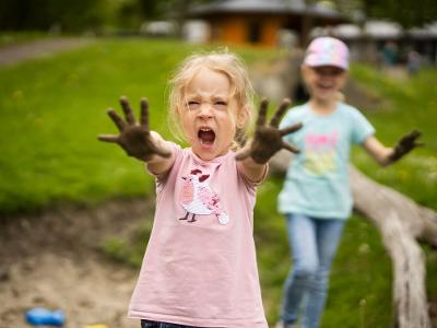 Lachendes Kind mit Matschhänden