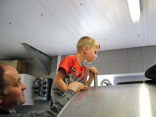 Junge schaut bei der Hofführung in die Milchwanne