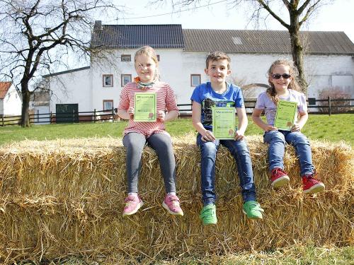 Kinder zeigen stolz ihr Melkdiplom
