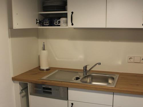 Küche mit Spülmaschiene, Geschirr, Lappen und Reinigungs- und Spülmitteln