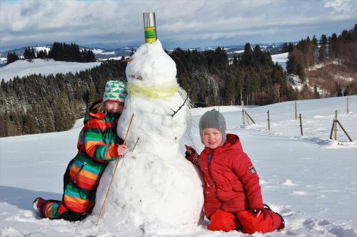 Winterfreuden: Kinder bauen Schneemann