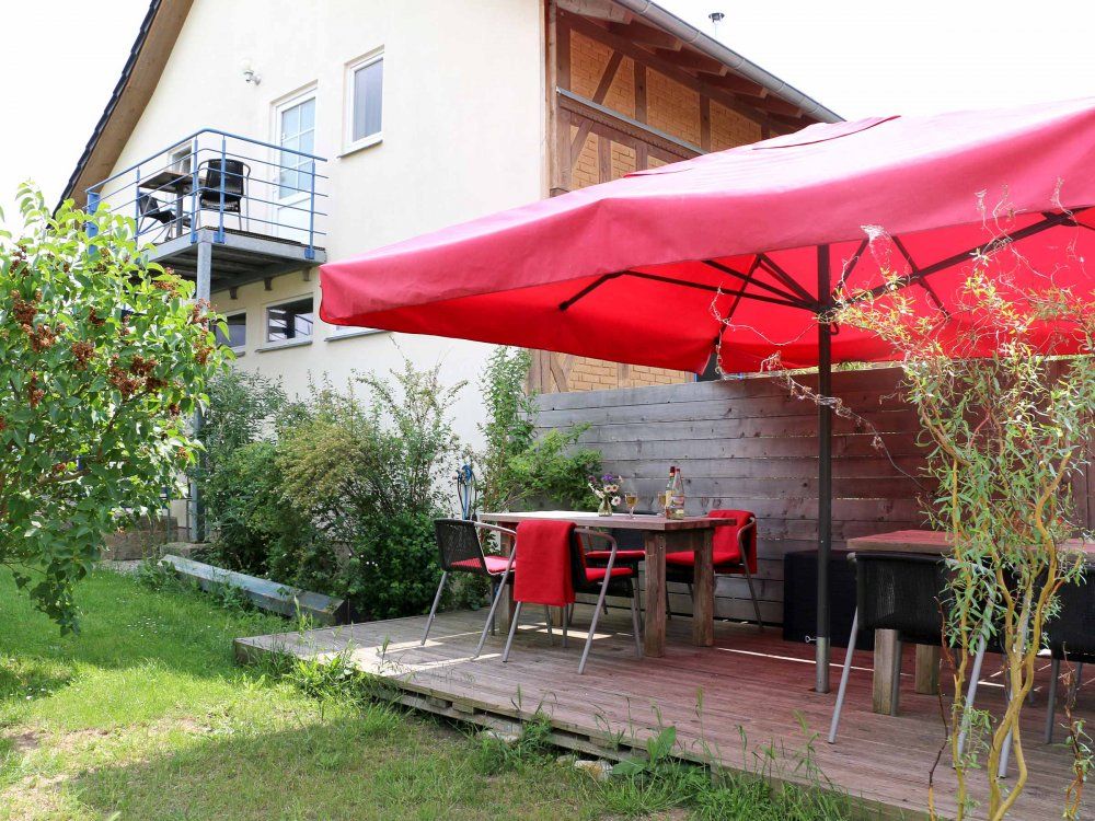 Gästegarten mit großem Sonnenschirm, Sitzkissen, Decken und Platzdeckchen in der Box