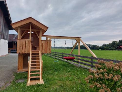 Spielhaus mit Schaukeln und Rutsche