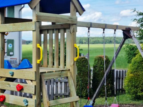 Spielturm mit Rutsche & Schaukel im Garten Spielturm mit Rutsche & Schaukel im Garten