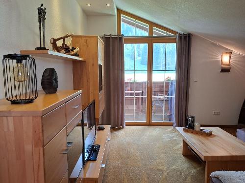 Wohnzimmer mit großzügiger Wohnwand und Ausblick nach Süden mit Balkon
